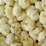 Multiple cloves of garlic in a grocery store.
