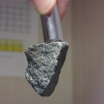 A neodymium magnet lifting a sample of magnetite.